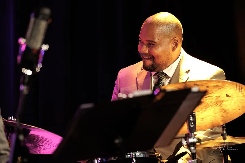 Sean behind the mic and music stand, listening to the band. Photo: Jeff Dunn Jazz Photography.